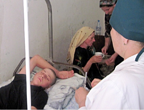 Teenager beaten by militiamen in the district hospital. His mother Aishat Guseinova is behind him. Dagestan, Shamil District, July 2010. Photo by the HRC "Memorial": www.memo.ru