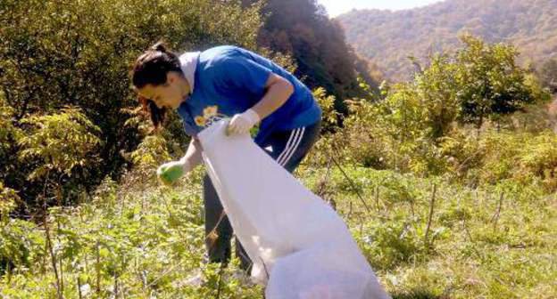 Ekaterina Begletsova, a participant of the action "Protect!", cleans the territory from household garbage. North Ossetia, Koban Gorge, October 10, 2011. Photo by Dmitry Tamerlanov for the "Caucasian Knot"