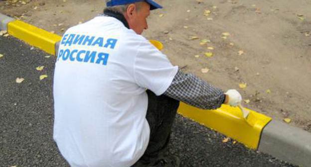 A campaigner of the "New Yards of United Russia" painting curbs in the yard of No. 60 in Kommunisticheskaya Street in the Lenin District of Astrakhan, October 13, 2011. Photo by Vyacheslav Yaschenko for the "Caucasian Knot"