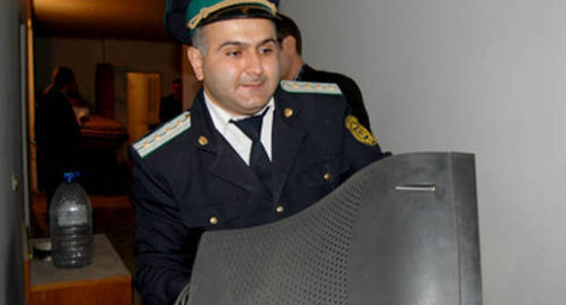 Azerbaijan, Baku, October 19, 2011, policemen confiscate property of the newspaper "Khural". Photo: Institute for Reporters' Freedom and Safety, www.irfs.az
 