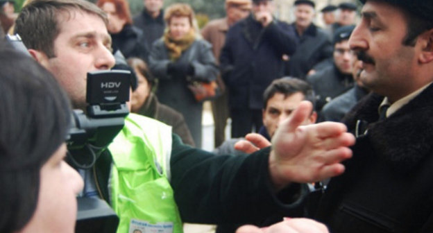 Репортер и полиция на митинге обманутых дольщиков перед зданием
 администрации президента Азербайджана. Баку, 18 января 2012 г. Фото:
www.irfs.az