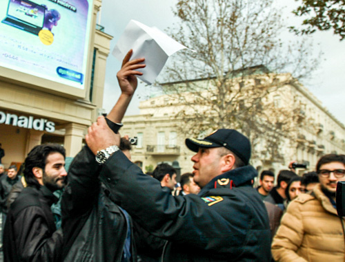 Baku, The Fountain Square, December 8, 2013. The policeman trying to prevent a silent protest against rise in fuel prices. Photo by Aziz Karimov for the ‘Caucasian Knot’. 
