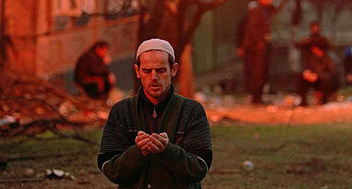 Chechen resident in praying, January 1995. Photo by Michael Evstafiev, https://upload.wikimedia.org/wikipedia/commons/thumb/7/7b/Evstafiev-chechnya-prayer3.jpg/640px-Evstafiev-chechnya-prayer3.jpg