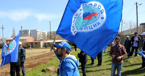 Activist of the "People Against Corruption" party holding flag. Photo: http://www.dagestanpost.ru/novosti/vrepublice/30593-aktivisty-iniciativnoj-gruppy-narod-protiv-korrupcii-vyshli-na-stroitelstvo-narodnogo-stadiona-v-maxachkale