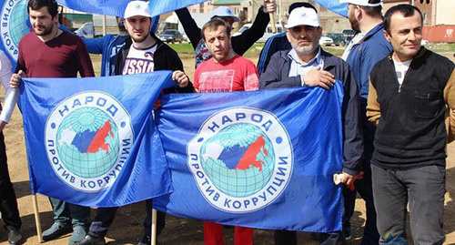 Activists of the "People Against Corruption" Party holding flag. Photo: http://www.dagestanpost.ru/novosti/vrepublice/30593-aktivisty-iniciativnoj-gruppy-narod-protiv-korrupcii-vyshli-na-stroitelstvo-narodnogo-stadiona-v-maxachkale