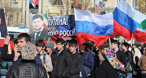 Students hold flags and Kadyrov's potraits durign rally on Day of Unity in Grozny, November 4, 2015. Photo by Magomed Magomedov for the 'Caucasian Knot'. 