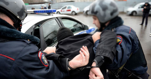 Policemen detain a man. Photo: Kiril Kalinikov (RFE/RL)