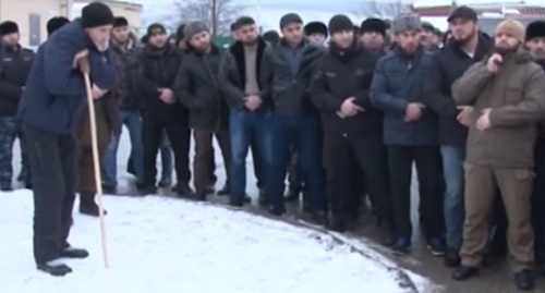 Aslanbek Bakharchiev stands in the circle (with a crutch) during gathering of local residents of the village of Prigorodnoye, December 21, 2016. Screenshot: https://www.youtube.com/watch?v=5Def1pvJo6U
