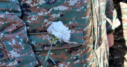 White carnation in the hands of soldier. Photo by Alvard Grigoryan for the 'Caucasian Knot'. 