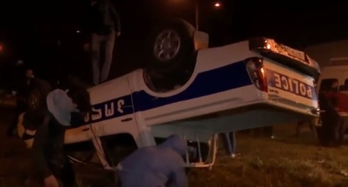 The police car turned upside down by the protesters. Photo: screenshot of a video on YouTube, https://www.youtube.com/watch?v=BREIJA6-SrI