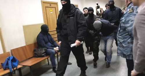 Shagid Gubashev, a defendant in the Boris Nemtsov's murder case, is convoyed through the corridor of the Basmanny Court of Moscow. Photo: Centre for Investigative Journalism http://investigator.org.ua/news/150556/