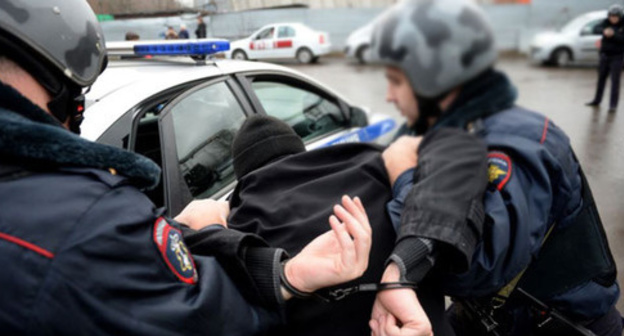 Policemen detain a person. Photo: Kiril Kalinikov (RFE/RL)