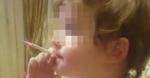 Screenshot of a video with a smoking child. Photo https://www.facebook.com/groups/respublikaalania/permalink/197991943232979