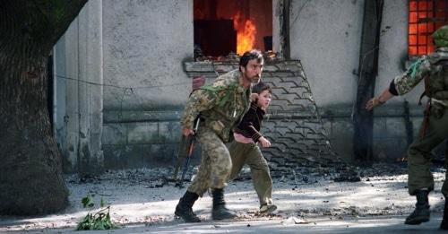 Fighter is taking a child away from the burning building in Sukhumi, 1993. Photo: Andrei Soloviev, RFE/RL