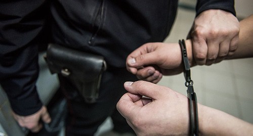 Policeman placing suspect in handcuffs. Photo: Elena Sineok / Yuga.ru
