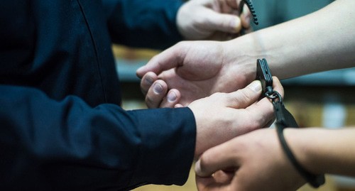 A law enforcer handcuffs a detainee. Photo by Yelena Sineok, Yuga.ru