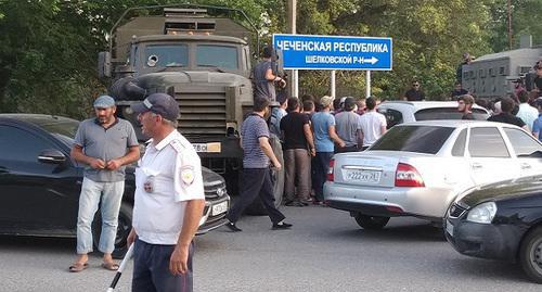 Law enforcers and protesters in Kizlyar near the Chechen road sign. Photo by Ilyas Kapiev for the "Caucasian Knot"