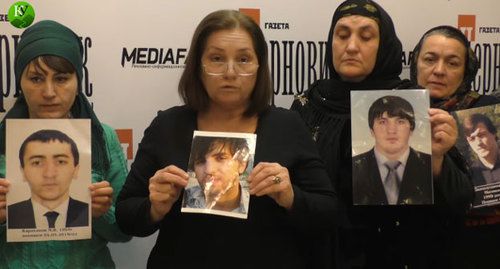 Relatives of the eight young people from Dagestan killed in Chechnya holding their photos. Screenshot of the video by the "Caucasian Knot"