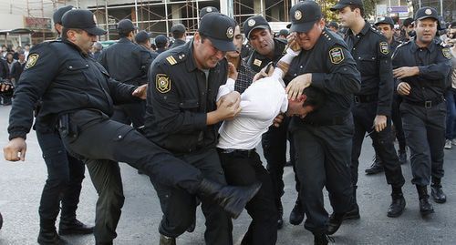 Policemen detaining an activist, Azerbaijan. Photo: REUTERS/David Mdzinarishvili