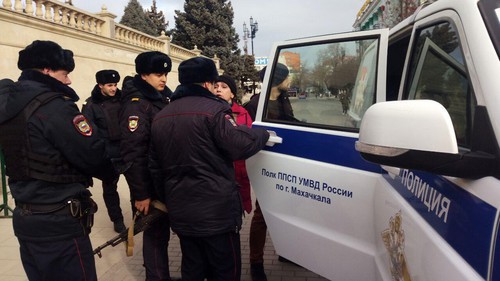 Policemen and activist Svetlana Anokhina (in red) at the square in Makhachkala. Photo by Murad Muradov for the Caucasian Knot