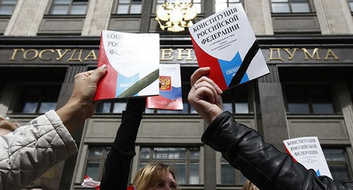 People holding the Constitution of Russia in front of the State Duma building. Photo: REUTERS/Sergei Karpukhin