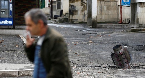 A resident of Stepanakert near an unexploded shell, October 2020. Photo: REUTERS/Stringer