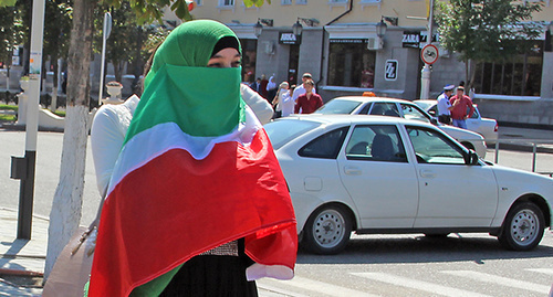 Woman covered her face with Chechen flag during celebrations of the Republic’s Day. Grozny, September 2014. Photo by Magomed Magomedov for the ‘Caucasian Knot’. 