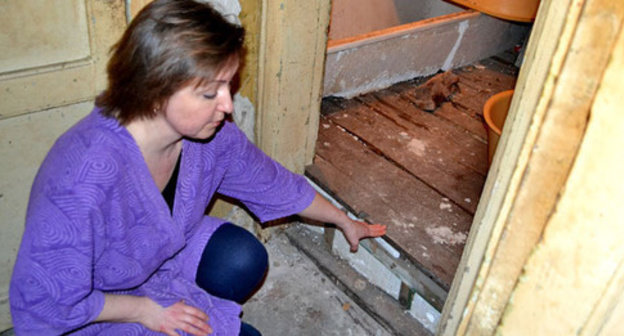 Anna Tkacheva shows the place in her bathroom where a ceiling beam collapsed. Sochi, March 6, 2015. Photo by Svetlana Kravchenko for the ‘Caucasian Knot’. 