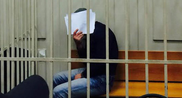 Anzor Gubashev shut his face from TV cameras and press photographers in the Basmanny Court room, March 8, 2015. Photo by Yuliya Buslavskaya for the "Caucasian Knot"