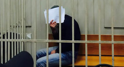 Anzor Gubashev shut his face from TV cameras and press photographers in the Basmanny Court room, March 8, 2015. Photo by Yuliya Buslavskaya for the "Caucasian Knot"