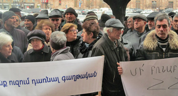 Protest action of the workers of the "Nairit" Factory. Inscriptions on the transparencies: "We don't want to be emigrants" (to the left), "Don't torture laws of the Republic of Armenia!" (to the right). Yerevan, March 5, 2015. Photo by Tigran Petrosyan for the "Caucasian Knot"