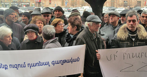 Protest action of the workers of the "Nairit" Factory. Inscriptions on the transparencies: "We don't want to be emigrants" (to the left), "Don't torture laws of the Republic of Armenia!" (to the right). Yerevan, March 5, 2015. Photo by Tigran Petrosyan for the "Caucasian Knot"