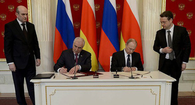 Vladimir Putin (right) and Leonid Tibilov (left) signing Russian-South-Ossetian alliance and integration treaty.