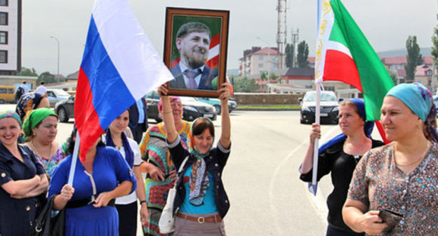 Chechnya residents with portrait of Ramzan Kadyrov. Photo by Akhmed Aldebirov for the ‘Caucasian Knot’. 