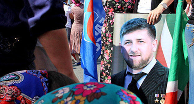 The participant of the action celebrating the day of the republic in Chechnya holds Ramzan Kadyrov's portrait. Grozny, September 6, 2014. Photo by Magomed Magomedov for the "Caucasian Knot'