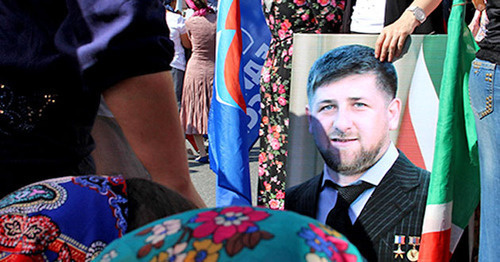 The participant of the action celebrating the day of the republic in Chechnya holds Ramzan Kadyrov's portrait. Grozny, September 6, 2014. Photo by Magomed Magomedov for the "Caucasian Knot'