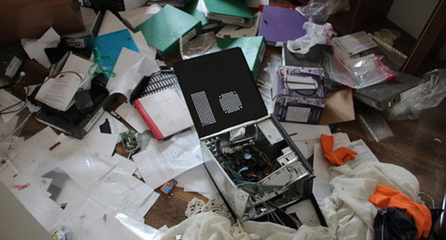 Broken personal computer lying on the heap of papers