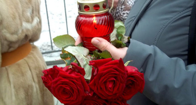 Participant of the funeral service for Boris Nemtsov holds candle and flowers. Moscow, March 3, 2015. Photo by Karina Gadzhieva for the "Caucasian Knot"