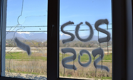 Inscription 'SOS' on the window of dilapidated house of cottage settlement for Olympic resettlers, Vesyoloe-Psou neighbourhood, Adler District of Sochi. Photo by Svetlana Kravchenko for the ‘Caucasian Knot’.
