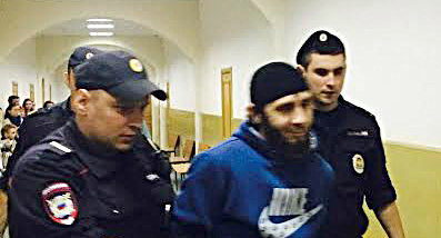 Police officer escorts Zaur Dadaev along the Basmanny Court hallway, Moscow, March 8, 2015. Photo by Yulia Buslavskaya for the ‘Caucasian Knot’