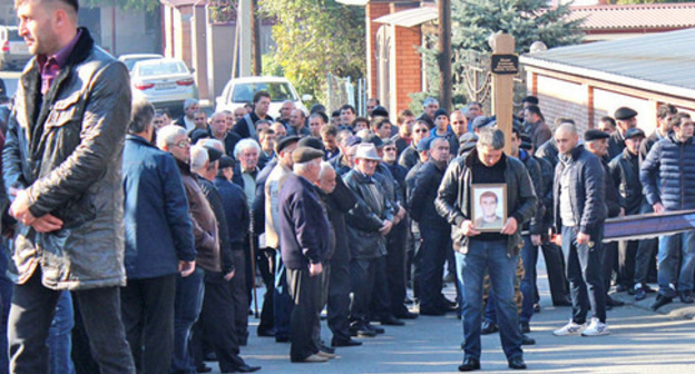 The participant of the funeral procession with Vladimir Tskaev's portrait. Photo by Emma Marzoeva for the "Caucasian Knot"