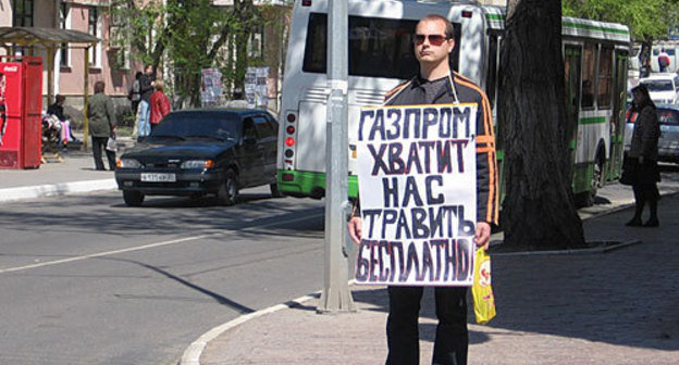 Activist with a poster at the LLC "Gazprom Dobycha Astrakhan". Poster: "Gazprom, stop poisoning us free of charge!" May 11, 2010. Photo by Alexander Alymov for "Caucasian Knot"