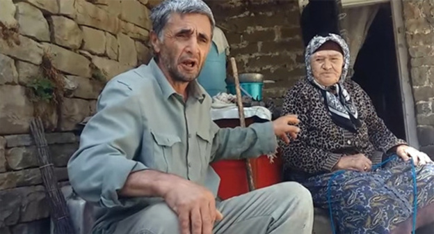 Ramazan Djalaldinov with an old woman in the village of Kenkhi. Screenshot of his video message on YouTube https://www.youtube.com/watch?v=T_oDJXutJJc
