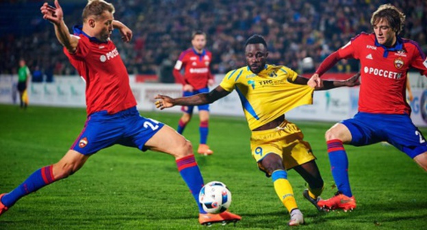 Kanga, a player of the "Rostov" Football Club (in the yellow uniform), fights for the ball with the footballists of the CSKA FC, the man rival of "Rostov" in the football championship of Russia. Photo: http://www.fc-rostov.ru/media/gallery/25395/album#19 