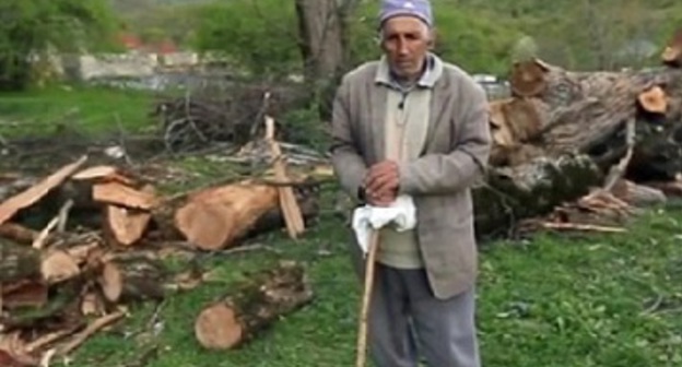 Georgy Doskoynov, a 79 year ethnic Udi living in the Oghuz city in Azerbaijan, near the cut down tree. Screenshot of a video by the "Caucasian Knot"