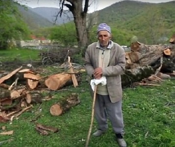 Georgy Doskoynov, a 79 year ethnic Udi living in the Oghuz city in Azerbaijan, near the cut down tree. Screenshot of a video by the "Caucasian Knot"