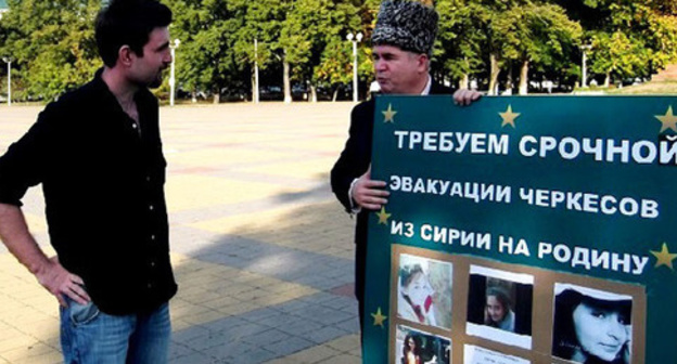Adnan Khuade (to the right) standing in a solo picket in a square in Maikop, Adygea. Photo: Hartpress