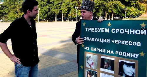 Adnan Khuade (to the right) standing in a solo picket in a square in Maikop, Adygea. Photo: Hartpress