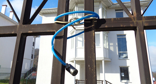 A padlock on a gate to the yard of the abandoned house in the "Olympic" settlement in Sochi. Photo by Svetlana Kravchenko for the "Caucasian Knot"