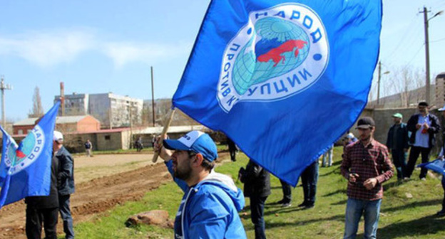 Activist of the "People Against Corruption" party holding flag. Photo: http://www.dagestanpost.ru/novosti/vrepublice/30593-aktivisty-iniciativnoj-gruppy-narod-protiv-korrupcii-vyshli-na-stroitelstvo-narodnogo-stadiona-v-maxachkale